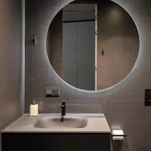 Replacement mirror being fitted in a residential bathroom