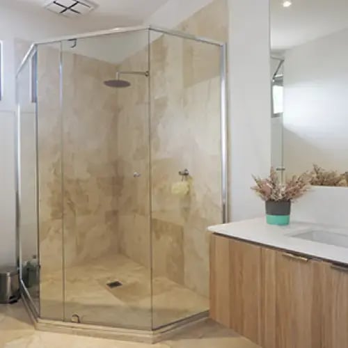 Semi-frameless shower enclosure with glass panels and metal frame