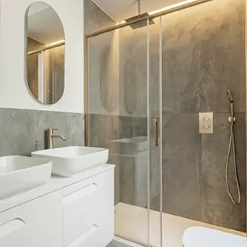Sliding glass shower enclosure over a bathtub